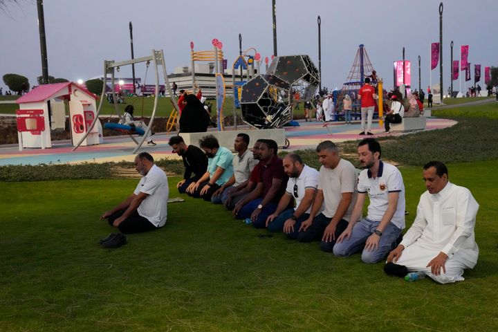 Μια ομάδα μουσουλμάνων ανδρών κάνουν βραδινή προσευχή πριν από την έναρξη του Παγκοσμίου Κυπέλλου, και τον ποδοσφαιρικό αγώνα μεταξύ Κατάρ και Ισημερινού έξω από το στάδιο Al Bayt στο Al Khor, Κατάρ, Κυριακή, 20 Νοεμβρίου 2022. (AP Photo/Aijaz Rahi)