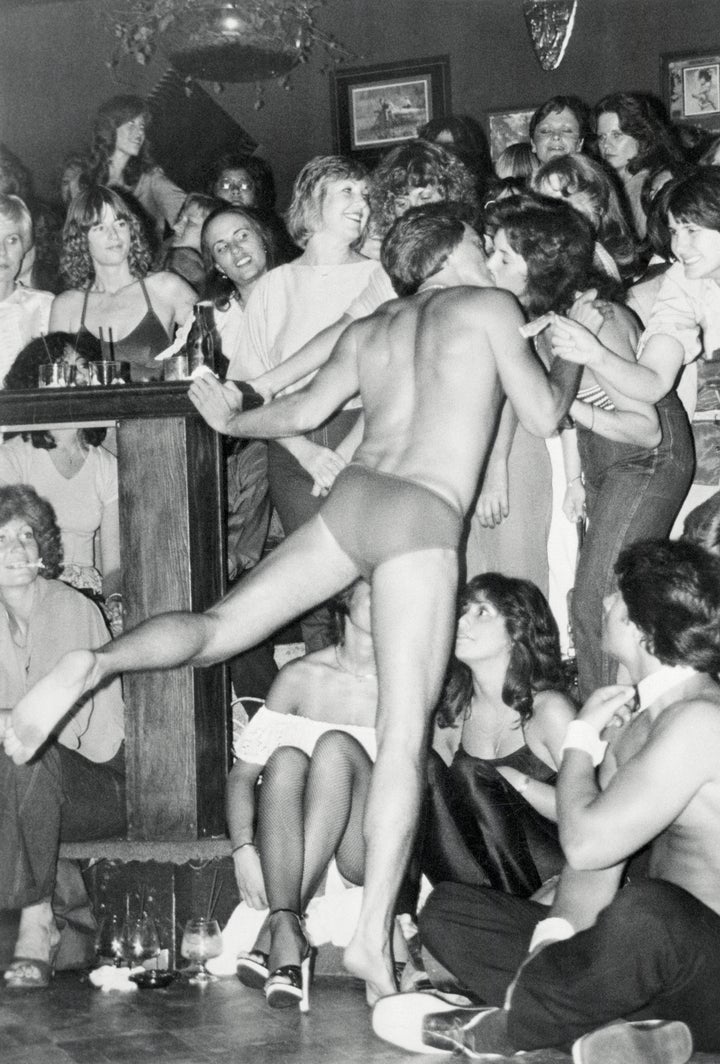 A male stripper and "ladies only" crowd pleaser collects a dollar tip in exchange for kissing a member of the audience during a performance at Chippendale's disco. 