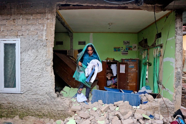 A man collects clothings from his damaged house following an earthquake in Cianjur, West Java, Indonesia, on Nov. 22, 2022. The earthquake has toppled buildings on Indonesia's densely populated main island, killing a number of people and injuring hundreds.