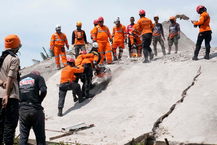 Rescuers cut through cement to recover the body of an earthquake victim from under the rubble of a collapsed building in Cianjur, West Java, Indonesia, on Nov. 22, 2022.