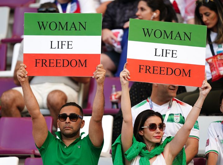 Iran fans in the stands hold up signs reading "Woman Life Freedom" ahead of the FIFA World Cup Group B match at the Khalifa International Stadium.