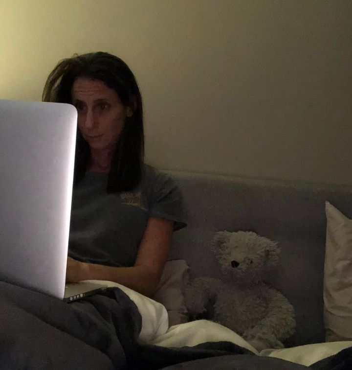 The author working on her memoir, "The Claimant," with Teddy propped up beside her.