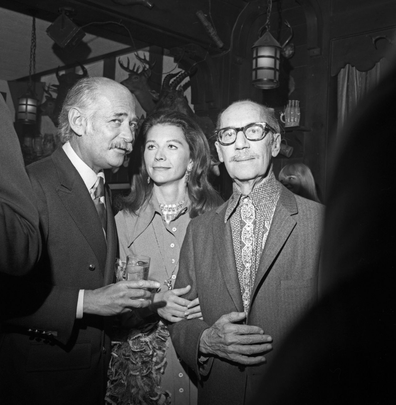 Lear (left) speaks with guests including Groucho Marx (right) at a cocktail party held for Lear at the 21 Club in New York City on May 1, 1972.