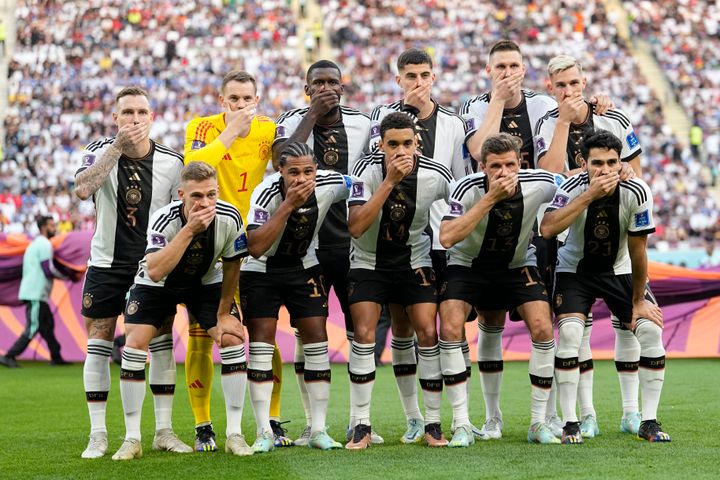 The Germany team lined up in the traditional formation before its game against Japan and all 11 players covered their mouths with their right hands in a coordinated gesture..