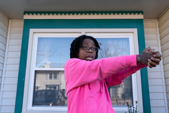 Briana Tyler speaks with The Associated Press and uses her hands like a gun as she demonstrates the gunman shooting indiscriminately, as she talks about witnessing the mass shooting at a Walmart, Wednesday, Nov. 23, 2022, in Chesapeake, Va.