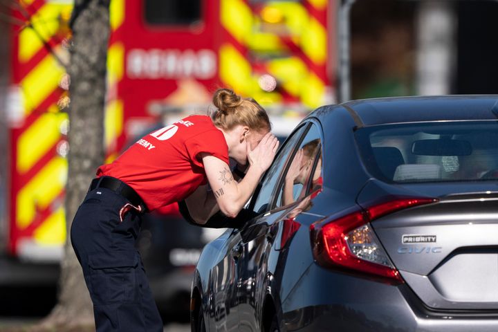 A first responder checks a parked car at the scene of a mass shooting at a Walmart, on Nov. 23, 2022, in Chesapeake, Va.