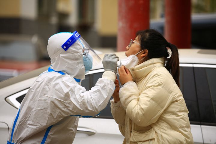 A health worker takes a swab sample from a resident to be tested for Covid-19 coronavirus in China this week
