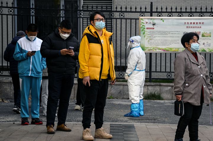 Peope queue for swab testing for the Covid-19 coronavirus at a collection site in Beijing on November 23, 2022 during a lockdown