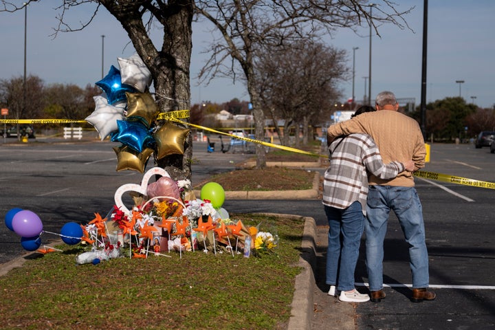 Debbie, left, and Chet Barnett place flowers at a memorial outside of the Chesapeake, Va., Walmart on Nov. 24, 2022.