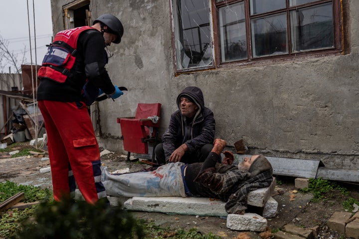 A Ukrainian paramedic treats Viktor Anastasiev who was injured during a Russian strike in Kherson, southern Ukraine, on Nov. 24, 2022.