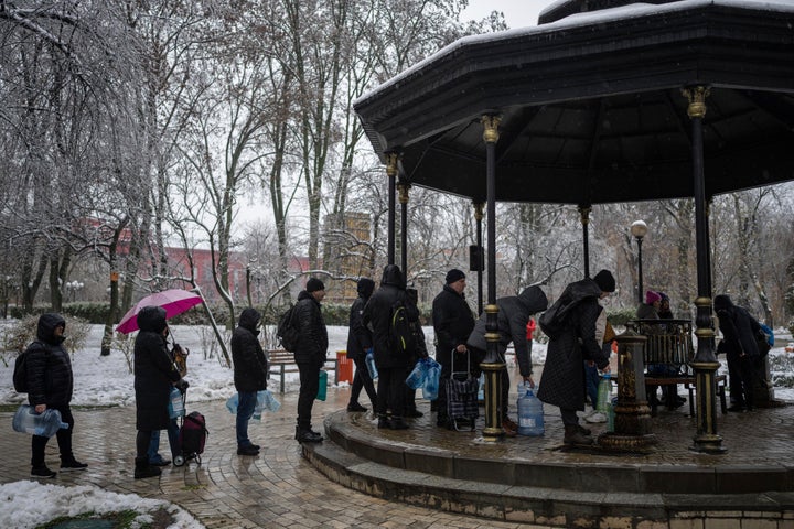 People wait in line to collect water, in Kyiv, Ukraine, on Nov. 24, 2022. Residents of Ukraine's bombed but undaunted capital clutched empty bottles in search of water and crowded into cafés for power and warmth Thursday, switching defiantly into survival mode after new Russian missile strikes a day earlier plunged the city and much of the country into the dark.