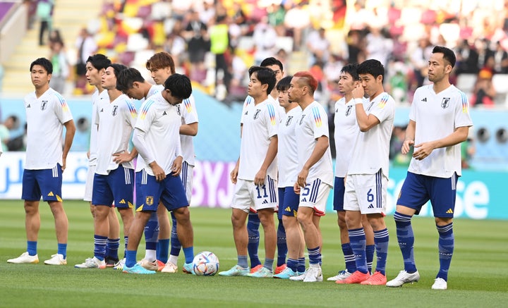 Japan players wear a practice shirt with rainbow stripes before their game against Germany.