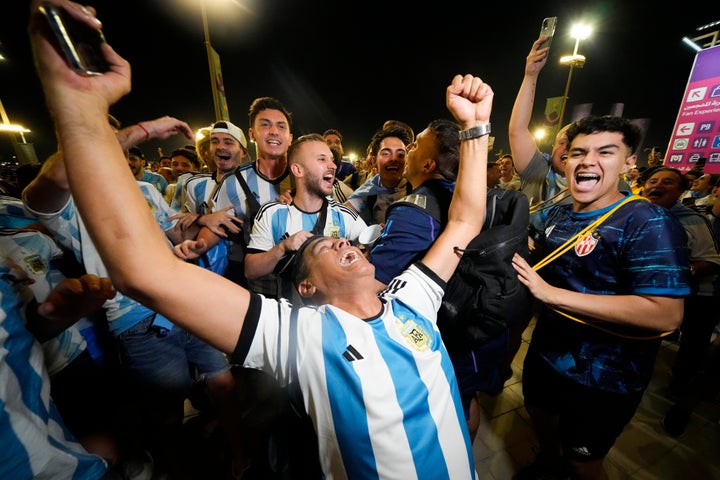 Les supporters argentins célèbrent devant le stade Lusail après la victoire 2-0 de leur équipe sur le Mexique lors d'un match de football du groupe C de la Coupe du monde à Lusail, au Qatar, le samedi 26 novembre 2022. (AP Photo/Julio Cortez)