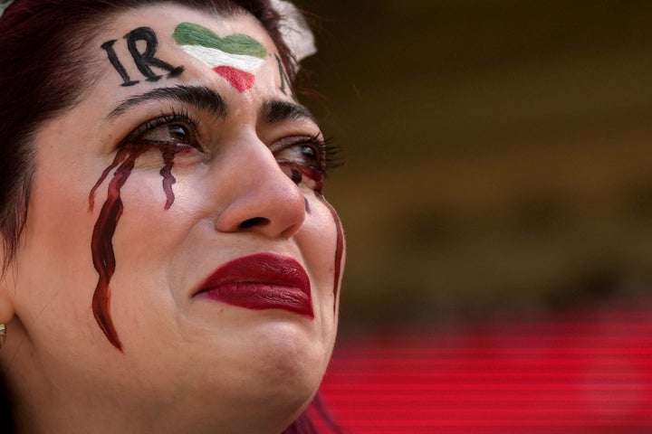 The Iranian woman, name not given, breaks into tears after a member of security seized her flag reading "Woman Life Freedom" before the start of the World Cup group B soccer match between Wales and Iran on Friday.