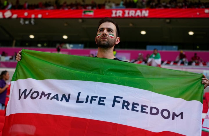 Daily News A soccer fan holds Iran's national flag on Friday with a message that supports the freedom for Iranian women in memory of Mahsa Amini, a woman who died while in police custody in Iran.