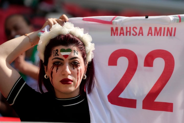 A woman shows a soccer shirt in memory of 22-year-old Mahsa Amini prior to the World Cup group B soccer match between Wales and Iran on Friday in Qatar.