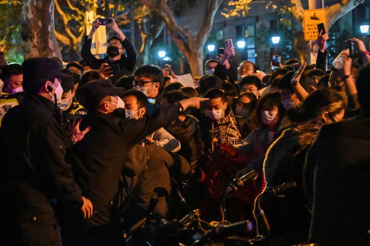 Police and protesters gather in Shanghai Sunday following a deadly fire in Urumqi, the capital of the Xinjiang region. 