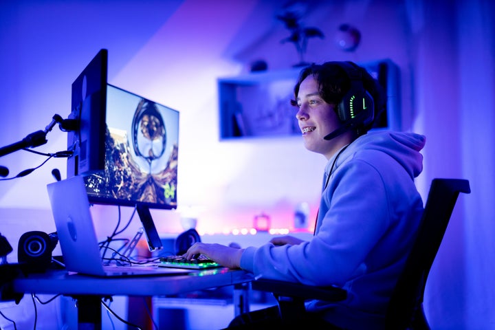 Teenager gaming online in his bedroom