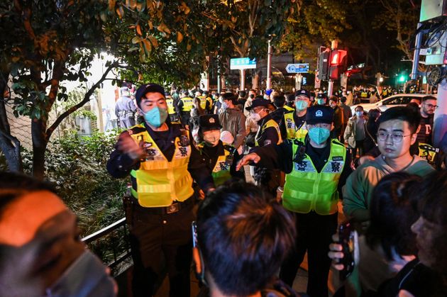 Police officers ask people to leave an area in Shanghai
