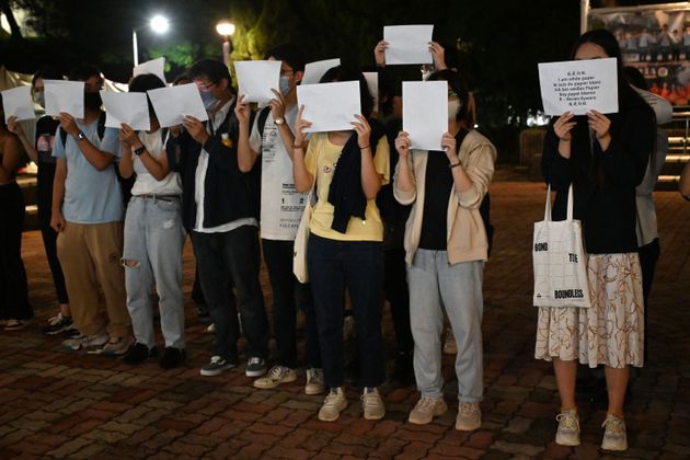 Students hold up placards including blank white sheets of paper on the campus of the Chinese University of Hong Kong, in solidarity with protests held on the mainland over Beijing's Covid-19 restrictions