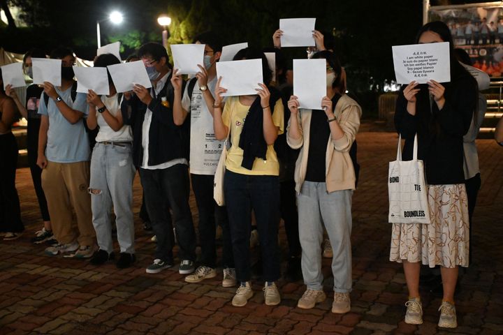 Students hold up placards including blank white sheets of paper on the campus of the Chinese University of Hong Kong, in solidarity with protests held on the mainland over Beijing's Covid-19 restrictions