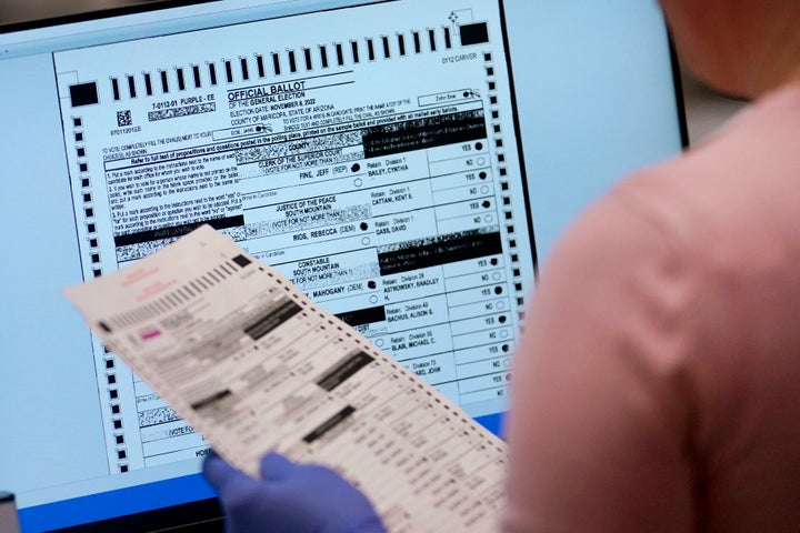 An election worker verifies a ballot on a screen inside the Maricopa County Recorders Office, Nov. 10, 2022, in Phoenix.