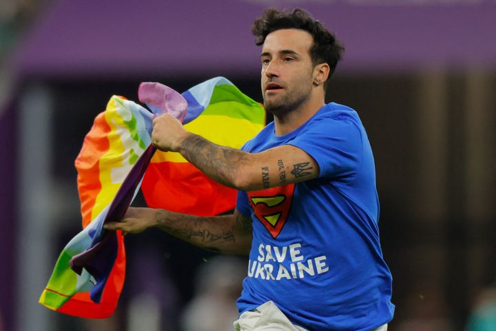 A protester wearing runs on the pitch waving a rainbow flag during the World Cup group H game between Portugal and Uruguay in Qatar.