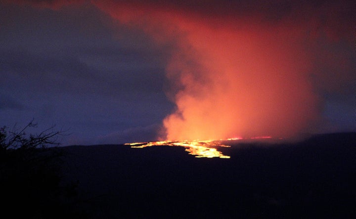 Lava pours out of the summit crater of Mauna Loa about 6:35 a.m. Monday, Nov. 28, 2022, as seen from Gilbert Kahele Recreation Area on Maunakea, Hawaii. Mauna Loa, the world’s largest active volcano, began spewing ash and debris from its summit, prompting civil defense officials to warn residents on Monday to prepare in case the eruption causes lava to flow toward communities. (Chelsea Jensen/West Hawaii Today via AP)