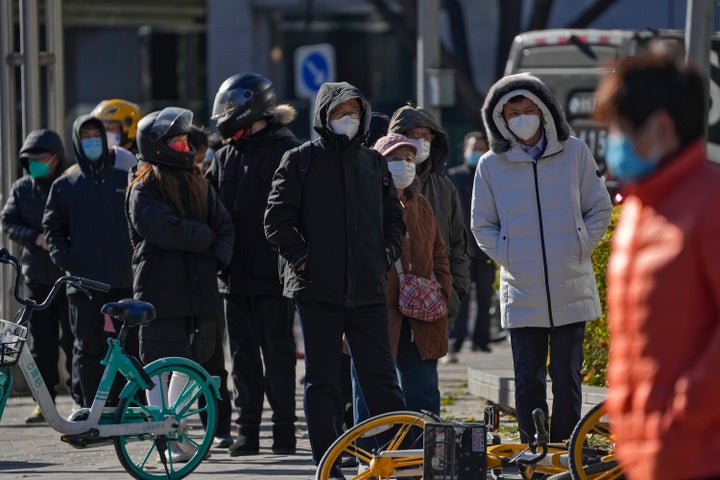 Residents stand in line for their routine COVID-19 tests in the freezing cold weather near the site of last weekend's protest in Beijing, Wednesday, Nov. 30, 2022. China's ruling Communist Party has vowed to "resolutely crack down on infiltration and sabotage activities by hostile forces," following the largest street demonstrations in decades staged by citizens fed up with strict anti-virus restrictions. (AP Photo/Andy Wong)