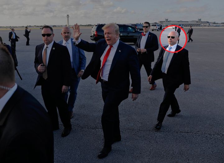 Then-President Donald Trump, center, surrounded by members of the Secret Service, including Tony Ornato, right, walks across the tarmac to begin to greet supporters during his arrival at Palm Beach International Airport, in West Palm Beach, Fla., on April 18, 2019. 
