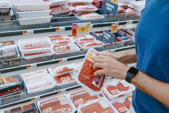 Close-up of unrecognizable white man checking the price of ground beef at supermarket