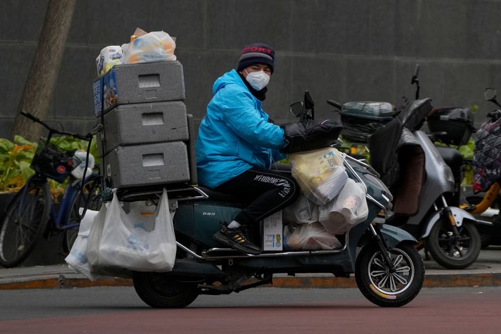 Ένας εργαζόμενος στο ντελίβερι οδηγεί ένα ποδήλατο φορτωμένο με είδη παντοπωλείου σε έναν δρόμο στο Πεκίνο, Δευτέρα, 28 Νοεμβρίου 2022. Οι αρχές χαλάρωσαν τους κανόνες κατά της πανδημίας σε διάσπαρτες περιοχές, αλλά επιβεβαίωσαν τη αυστηρή στρατηγική της Κίνας "μηδενικού COVID". Διαδηλωτές ζητούν ωστόσο την παραίτηση του Προέδρου της Κίνας, Σι Τζινπίνγκ. (AP Photo/Andy Wong)