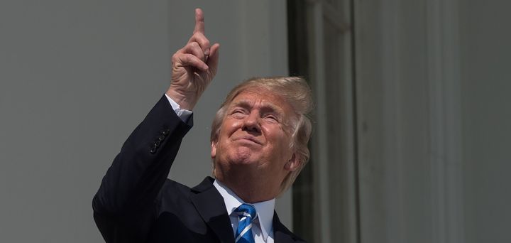 U.S. President Donald Trump stares directly at the sun during a partial solar eclipse on Aug. 21, 2017.