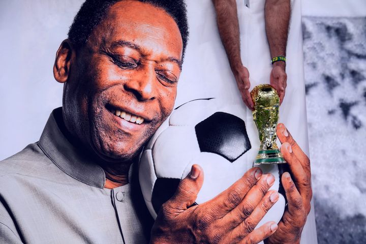A Brazil fan holds a replica World Cup trophy over a picture of former player Pele ahead of the FIFA World Cup Group G match at the Lusail Stadium in Lusail, Qatar. Picture date: Friday December 2, 2022. (Photo by Peter Byrne/PA Images via Getty Images)