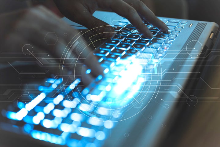 Close-up photograph of a woman's hands working with her laptop