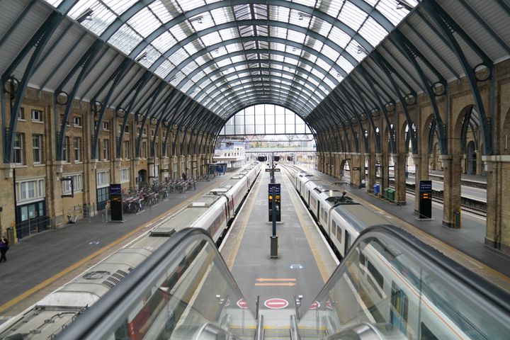 Empty platform and stationary trains at Kings Cross station in London.