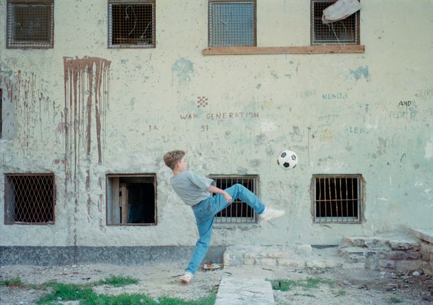 紛争中のクロアチアの都市ザダールでサッカーボールで遊ぶ少年（1994年11月撮影）