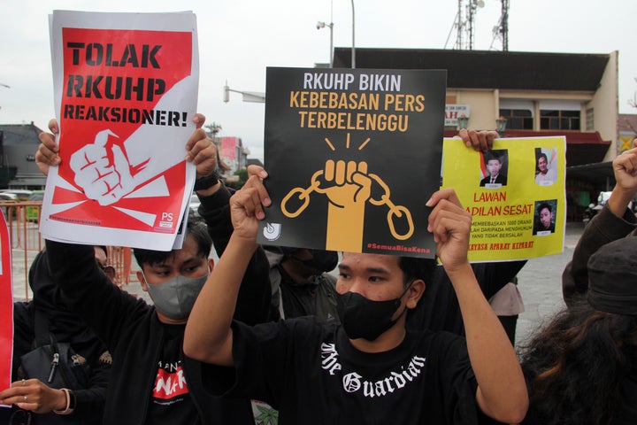 Activists hold up posters during a rally against Indonesia's new criminal law in Yogyakarta, Indonesia, on Dec. 6, 2022. The country's parliament passed the long-awaited and controversial revision of its penal code Tuesday that criminalizes extramarital sex for citizens and visiting foreigners alike. Writings on the posters read "Reject the revised penal code" and "Revised criminal law shackles press freedom." 