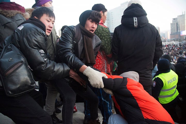 Protesters gather near the State Palace on Sukhbaatar Square in Ulaanbaatar in Mongolia on Monday, Dec. 5, 2022. Protesters angered by allegations of corruption linked to Mongolia's coal trade with China have stormed the State Palace in the capital, demanding dismissals of officials involved in the scandal. (AP Photo/Alexander Nikolskiy)