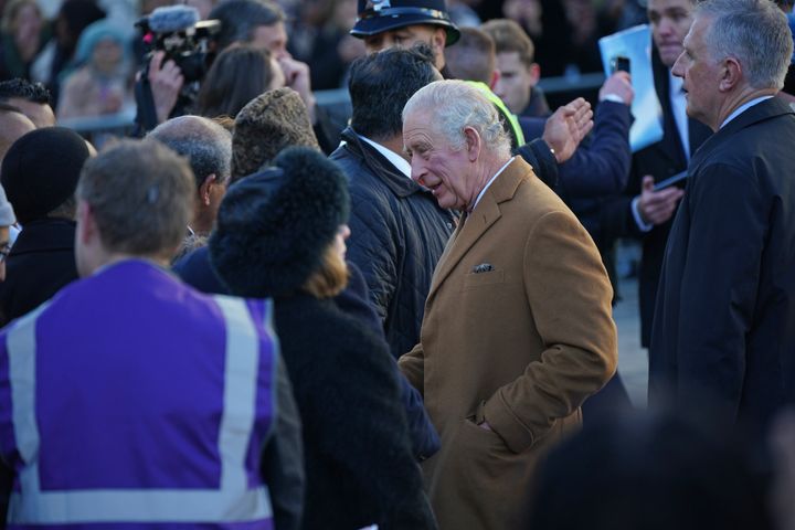 A close-protection officer (right) watches the crowd as King Charles III meets members of the public during a visit to Luton.