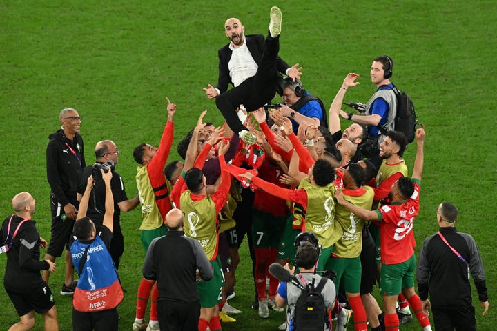 Morocco's players throw coach Walid Regragui in the air as they celebrate their victory over Spain.