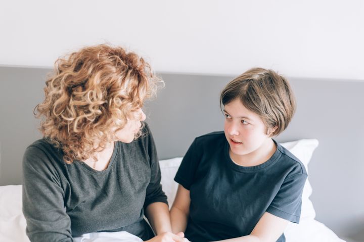Mother and teenager daughter in bed arguing