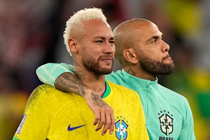 Brazil's Neymar, left, has tears in his face beside Brazil's Dani Alves, right, after losing the World Cup quarter-final.