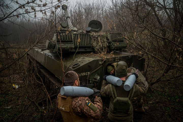 Ukrainian artillerymen from the 24th brigade load ammunition into a 2S1 Gvozdika self-propelled howitzer along the front line near Bakhmut on Dec. 10.