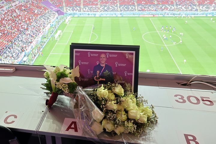 AL KHOR, QATAR - DECEMBER 10: Flowers and a picture in memory of Grant Wahl, an American sports journalist who passed away whilst reporting on the Argentina and Netherlands match, are placed prior to the FIFA World Cup Qatar 2022 quarter final match between England and France at Al Bayt Stadium on December 10, 2022 in Al Khor, Qatar. (Photo by Hector Vivas - FIFA/FIFA via Getty Images)
