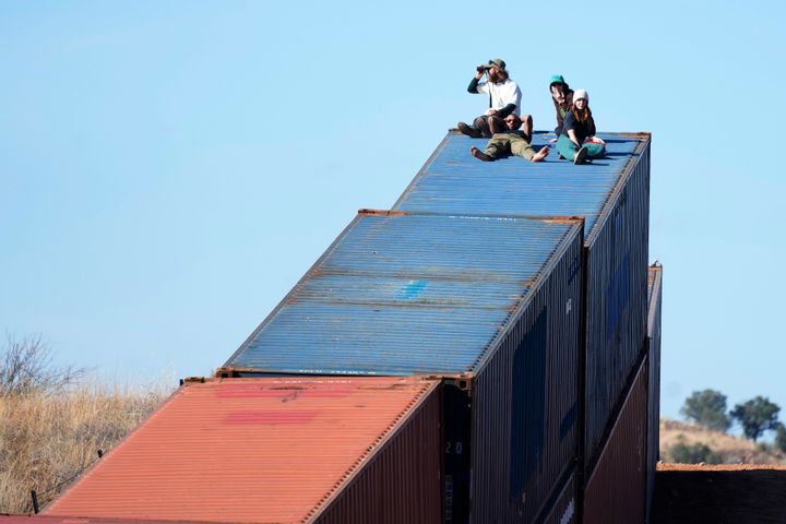 Activists sit on newly installed shipping containers along the border creating a wall between the United States and Mexico in San Rafael Valley, Ariz. 