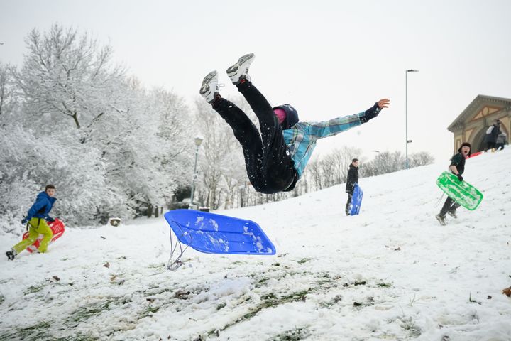 A man takes to the air after hitting a ramp while sledging in Alexandra Park on Monday