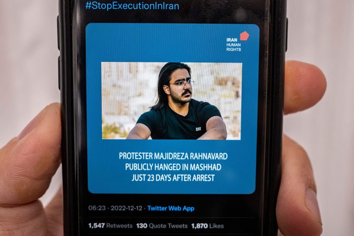 A person in the Cypriot capital Nicosia checks a mobile phone on Dec. 12, 2022, displaying a tweet about the execution announced by Iranian authorities of Majidreza Rahnavard, the second capital punishment linked to nearly three months of protests.