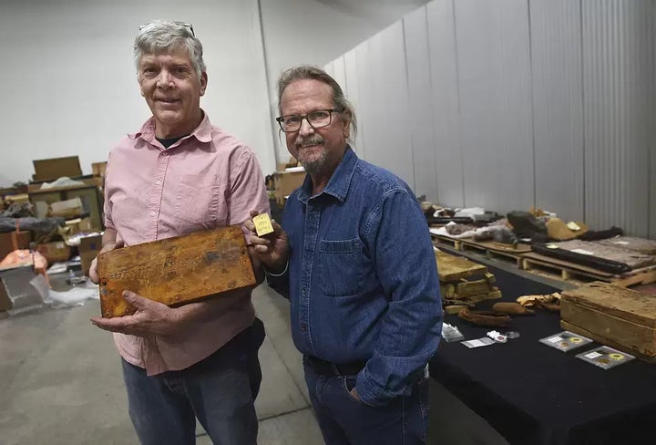 Fred Holabird, left, and Bob Evans pose with artifacts including a Wells Fargo treasure box lid from the S.S. Central America in a warehouse in Sparks, Nevada, on May 4.