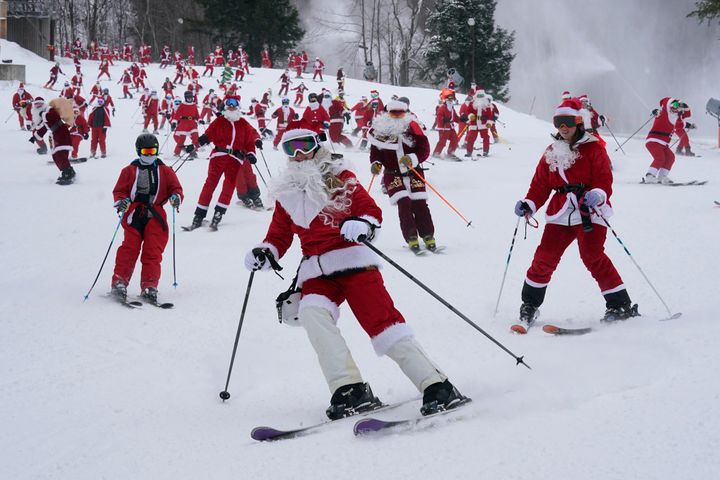 Skiers dressed in Santa Claus outfits hit the slopes for charity at the Sunday River Ski Resort, Sunday, Dec. 11, 2022, in Newry, Maine. (AP Photo/Robert F. Bukaty)
